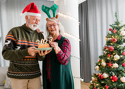Festively dressed couple in front of christmas tree